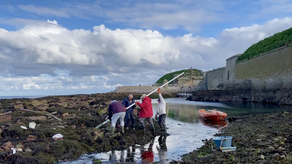 Bénévoles posant un poteau de balisage à l'entrée du port