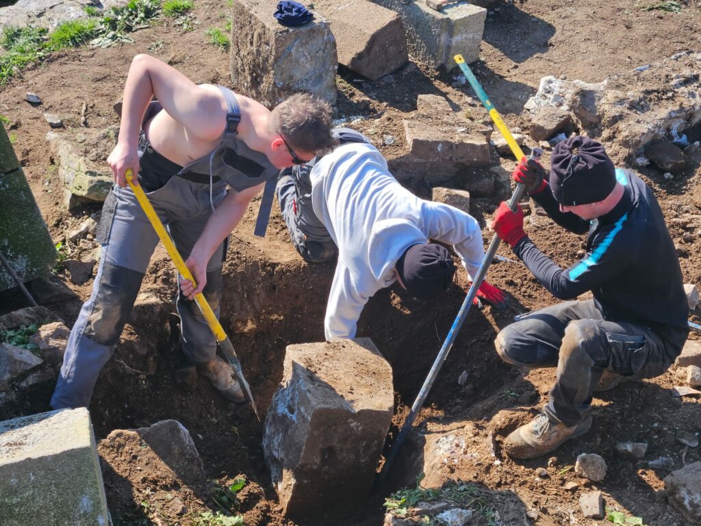 Chantier S10 en mars 2026 avec le lycée Laplace : Trois élèves interviennent pour dégager bloc de pierre taillée issu du petit magasin à poudre